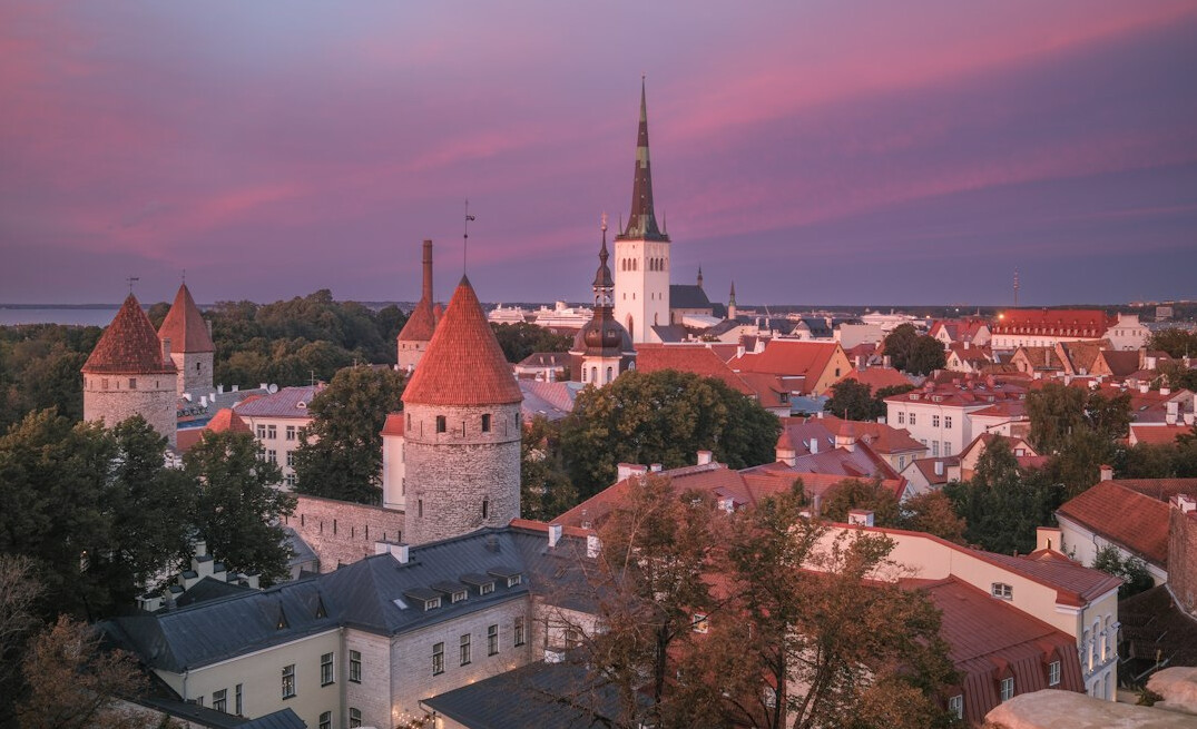 Historic city skyline with towers and red roofs at dusk