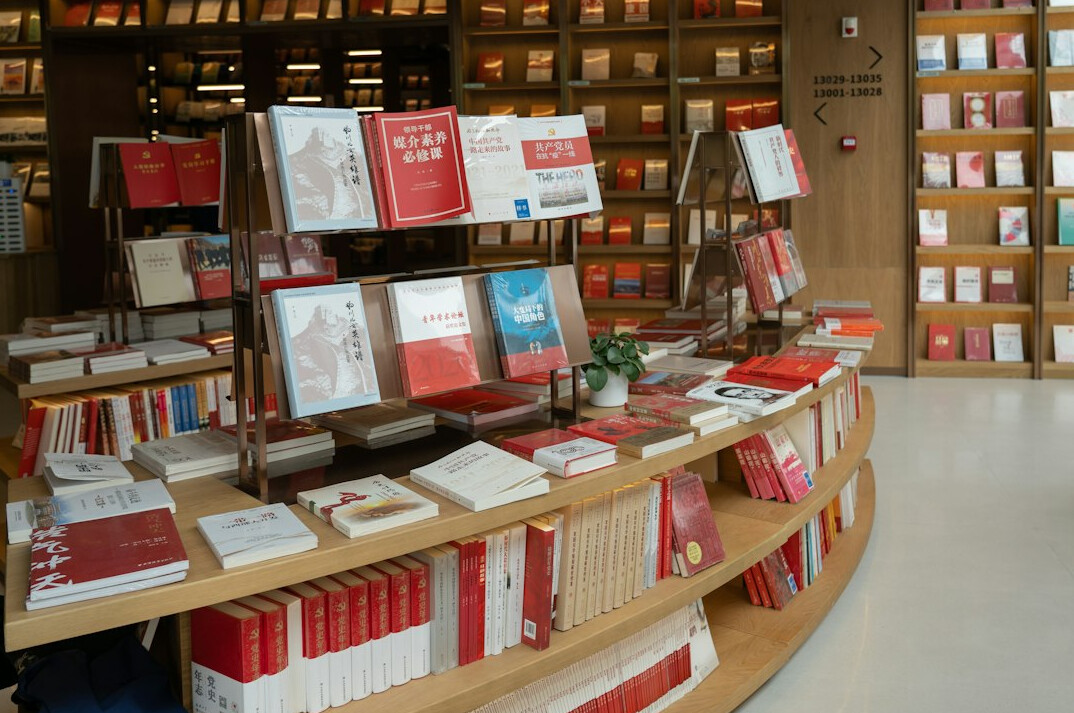 Bookstore shelves with books arranged by spine colour