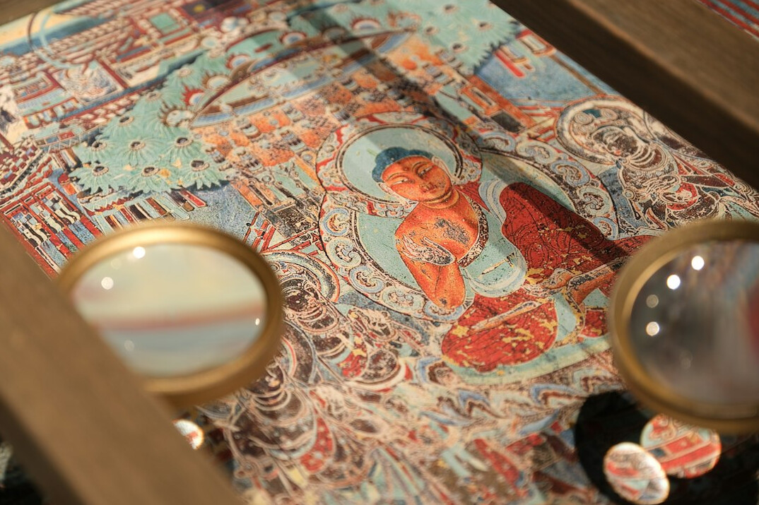 Antique map spread on a table with a magnifying glass