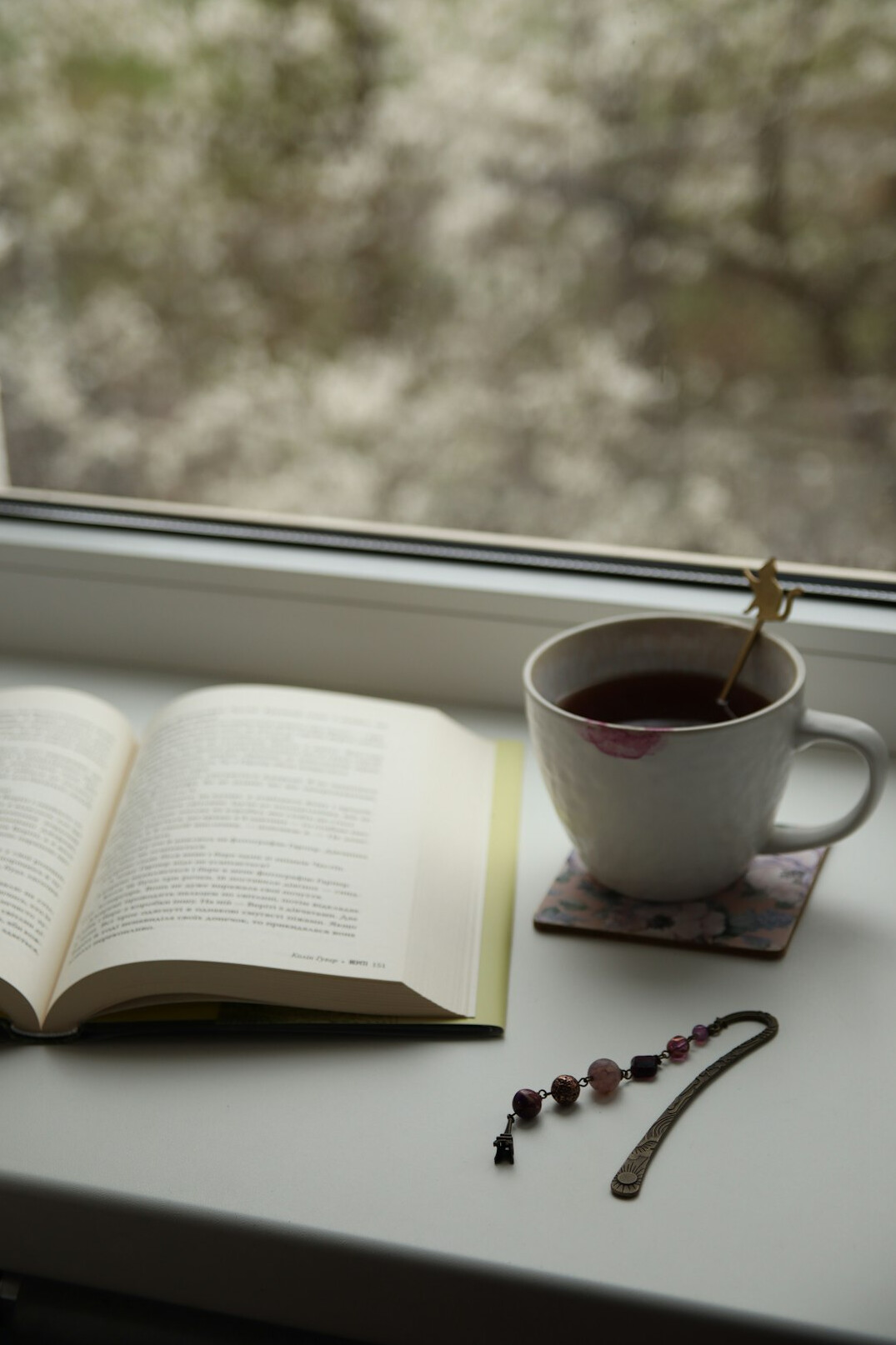 Writing desk with notebook, pen and a cup of tea near a window